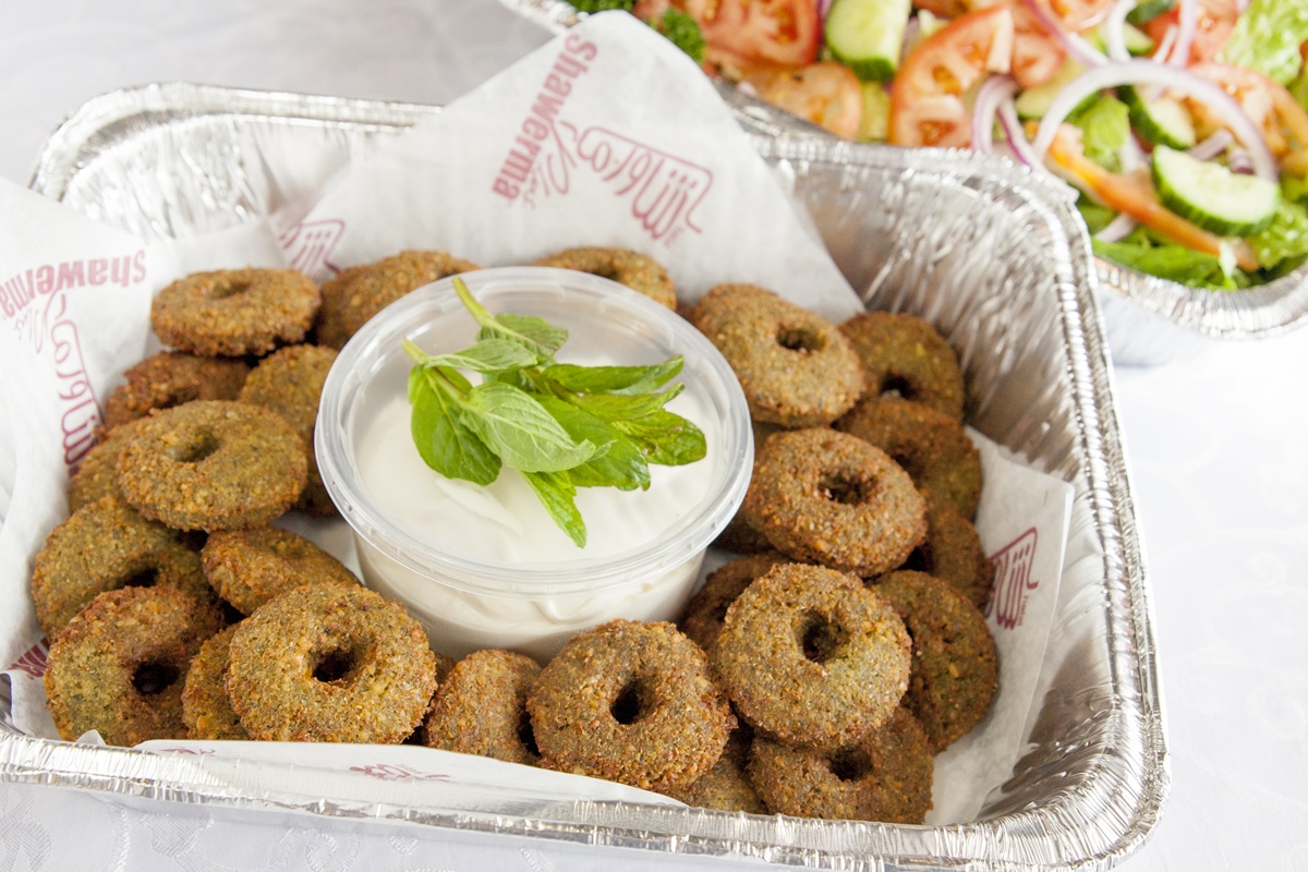 Catering buffet tray of falafel with tahini and fresh salad